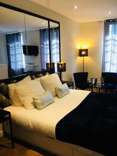 a bedroom with a large bed with white sheets and pillows at Les Mille et une Nuits in Rouen