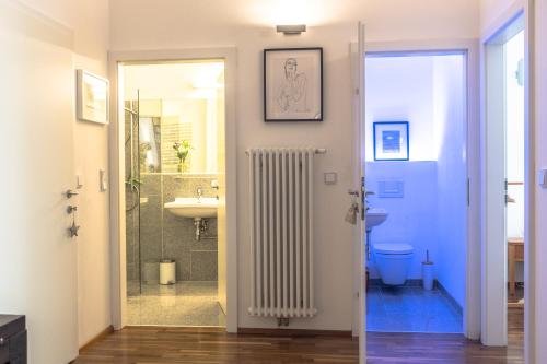 a bathroom with a white radiator next to a sink at Spacious old town luxury apartment in Linz