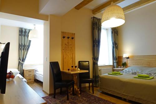ザコパネにあるOśrodek Wypoczynkowy Tatrzańskaのベッドルーム1室(ベッド1台、テーブル、椅子付)