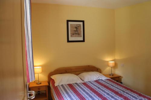 1 dormitorio con 1 cama con 2 lámparas en 2 mesas en Résidence Atrey Clés Blanches en La Tania