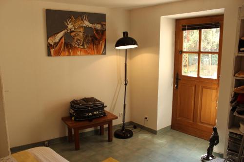 a room with a suitcase on a table and a lamp at L'ateliere in Ottrott