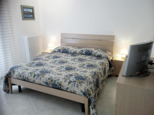 a bedroom with a bed and a computer on a desk at "Il Giardino Di Niu" in Palombaro