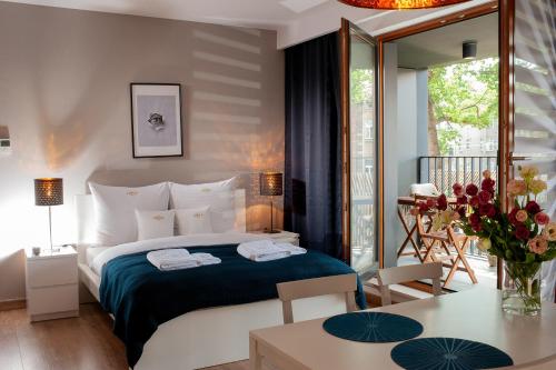 a bedroom with a bed and a table with flowers at Browar Lubicz Residence in Krakow