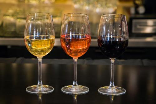 three wine glasses sitting on top of a table at Ramada by Wyndham Austin South in Austin