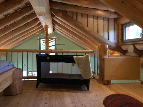 a room with a crib in a wooden attic at Holzhauszeit in Laudenbach
