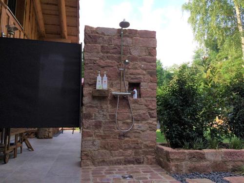 a bathroom with a shower in a stone wall at Holzhauszeit in Laudenbach