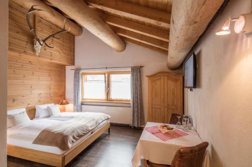 Un dormitorio con una cama y una mesa. en Hotel Suretta, en Splügen