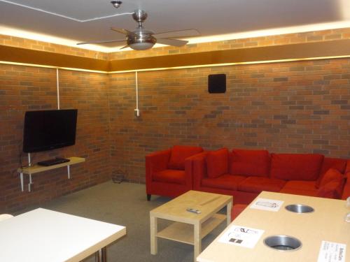 a living room with a red couch and a tv at University of Toronto - New College Residence - Wilson Hall Residence in Toronto