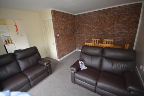 a living room with a couch and a table at Causeway Coast Apartment in Ballycastle