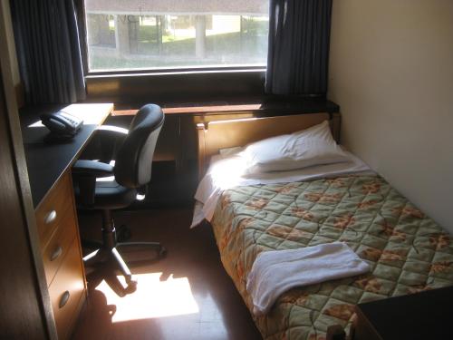 um quarto com uma cama, uma secretária e uma cadeira em University of Toronto - New College Residence - Wilson Hall Residence em Toronto