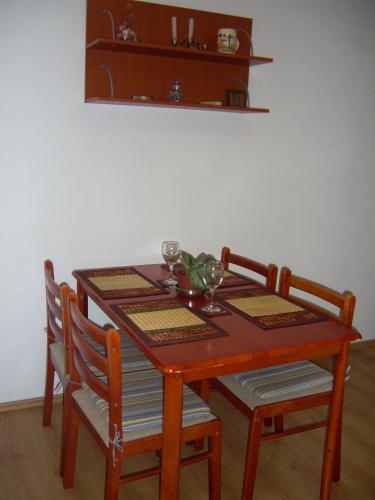 a wooden table with two chairs and a table with wine glasses at Apartments Villa More in Makarska