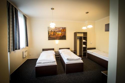 a room with two beds and a painting on the wall at Hotel Sázavský Ostrov in Sázava