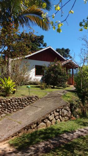 a house with a stone path in front of it at Pousada na Colina in Visconde De Maua