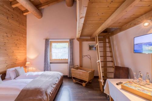 a bedroom with a bunk bed and a ladder at Hotel Suretta in Splügen