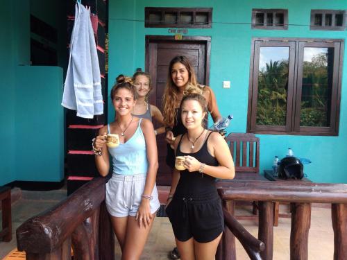 um grupo de mulheres posando para uma foto com bebidas em Breeze Hostel em Kuta Lombok