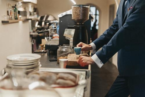 a man standing in a kitchen preparing food at Miss Sophie's Olomouc - Boutique Hotel in Olomouc