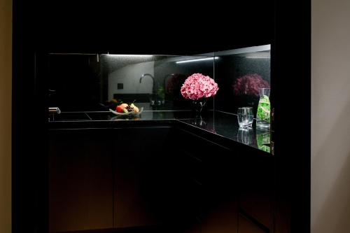 a kitchen with a black counter with flowers and a sink at Hotel Schweizerhof Bern & Spa in Bern