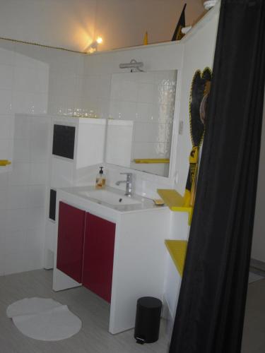 a bathroom with a sink and a red and white cabinet at Les jardins de VIX in Vix