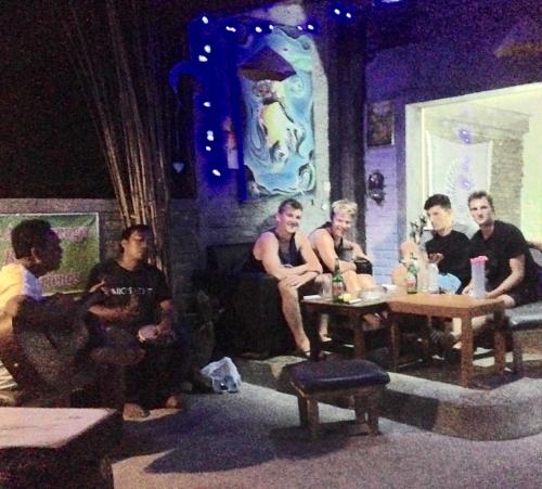 a group of men sitting around a table in a room at Apollo Hostel in Lovina