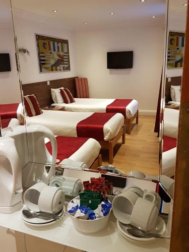 a hotel room with two beds and a mirror at Westpoint Hotel in London