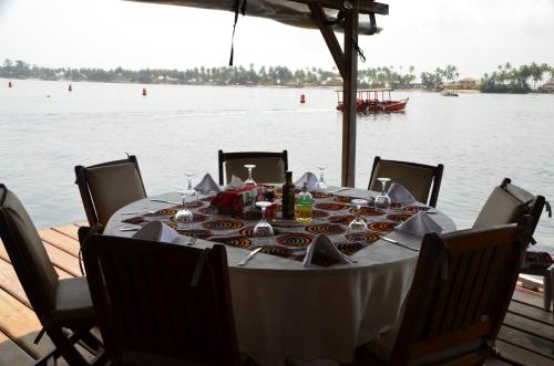 a table with a white table cloth on the water at Hotel Coucoue Lodge in Assinie