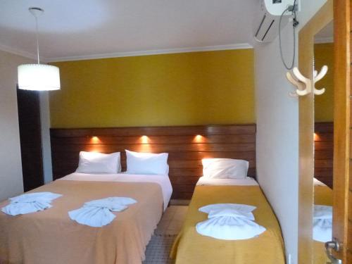 um quarto de hotel com duas camas com almofadas brancas em Las Balsas Hotel em Federación