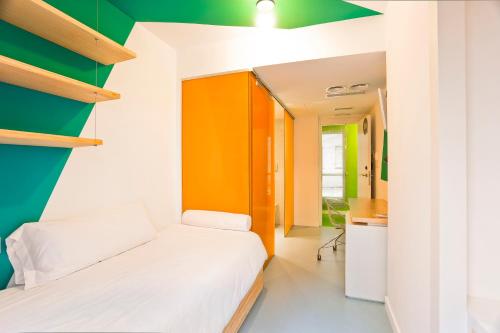 1 dormitorio con 1 cama y una pared verde y blanca en Students XD, en Granada