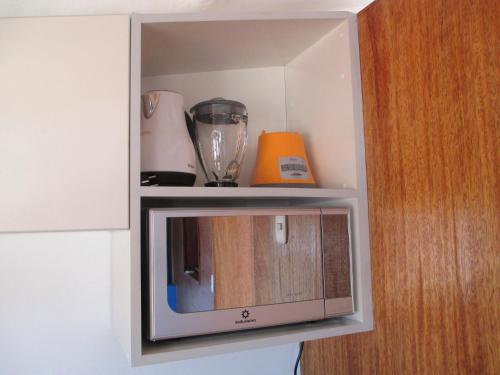 a cupboard with a small microwave in it at Quinua Boutique Apartments in Cusco