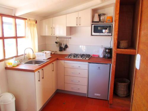 a small kitchen with a sink and a stove at Quinua Boutique Apartments in Cusco