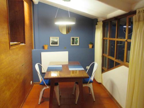 a dining room with a wooden table and chairs at Quinua Boutique Apartments in Cusco
