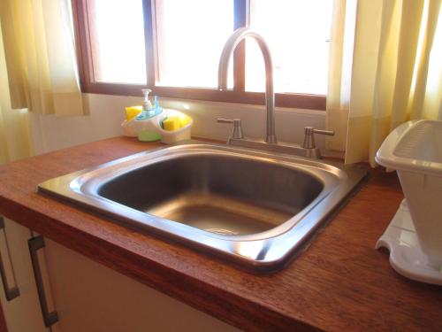 a stainless steel sink in a bathroom with a window at Quinua Boutique Apartments in Cusco
