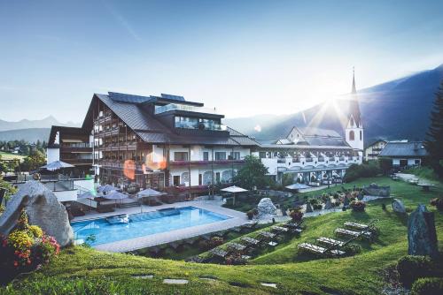 ein Hotel mit einem Pool und einem Gebäude in der Unterkunft Hotel Klosterbräu in Seefeld in Tirol