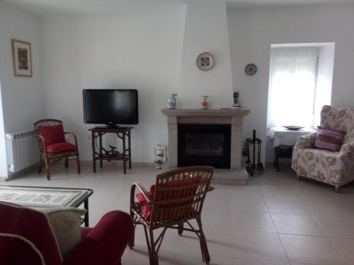 a living room with a fireplace and a tv at Casa Rural Mimbrero in Aldeadávila de la Ribera