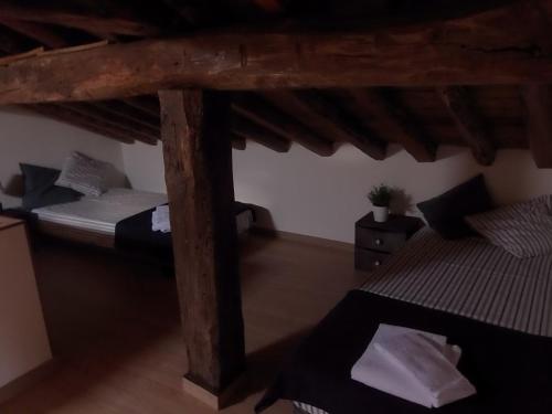a room with two beds and a wooden ceiling at Casa Rural Los Robles in Valverde de los Arroyos