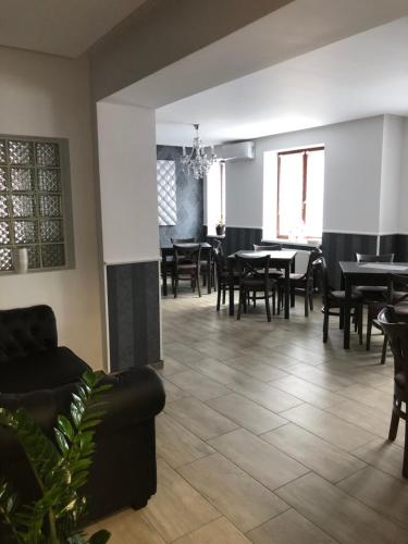 a dining room with tables and chairs and a couch at Tardosi Vendégház in Miskolctapolca