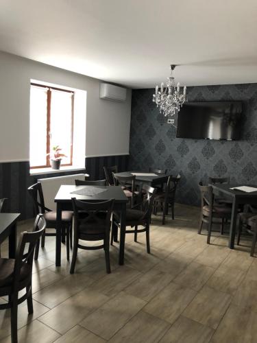 a dining room with tables and chairs and a chandelier at Tardosi Vendégház in Miskolctapolca