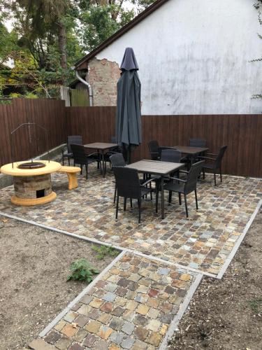 un patio con tavoli, sedie e ombrellone di Tardosi Vendégház a Miskolctapolca