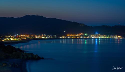 a large body of water with a city at night at Oasis in Sarti