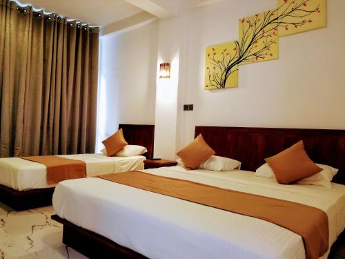 um quarto de hotel com duas camas e uma janela em Queens mount em Kandy