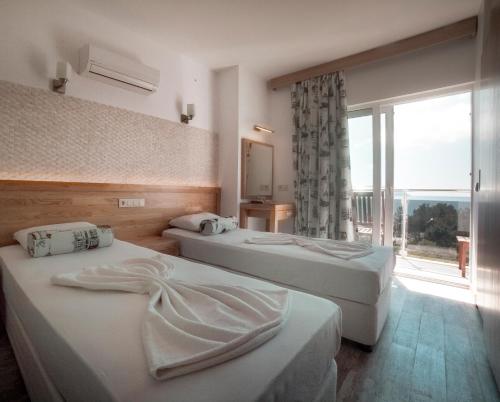 a hotel room with two beds and a window at Nur Hotel in Kaş