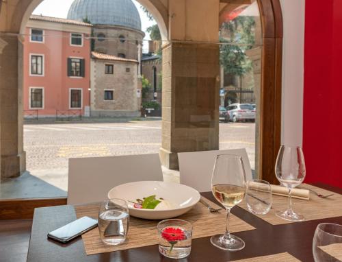 a table with a plate of food and wine glasses at Hotel Casa Del Pellegrino in Padova