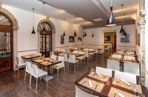 a restaurant with wooden tables and white chairs at Hotel Casa Del Pellegrino in Padova