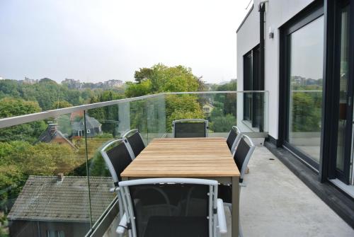 a balcony with a wooden table and chairs at Penthousewohnung in Mettmann