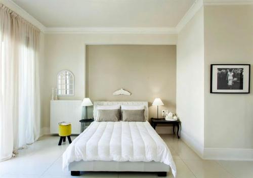 a white bedroom with a large white bed in it at Maritina Apartment in Heraklio
