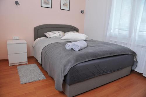 a bedroom with a large bed with two towels on it at Studio apartman D&D in Varaždin