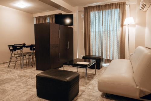 ein Wohnzimmer mit einem Sofa und einem Tisch in der Unterkunft Vecchia Terra Apart Hotel in San Rafael