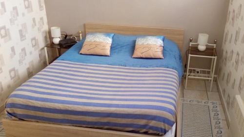 une chambre avec un lit avec une couverture rayée bleue et blanche dans l'établissement FLAB' MARIN, au Tréport