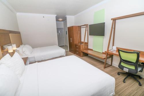 a hotel room with two beds and a desk at Holiday Inn Express Hotel & Suites Greenville by IHG in Greenville
