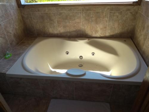 a bath tub in a bathroom with a window at Pousada na Colina in Visconde De Maua