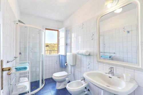 a bathroom with a sink and a toilet and a mirror at Rosa dei Venti in Capoliveri